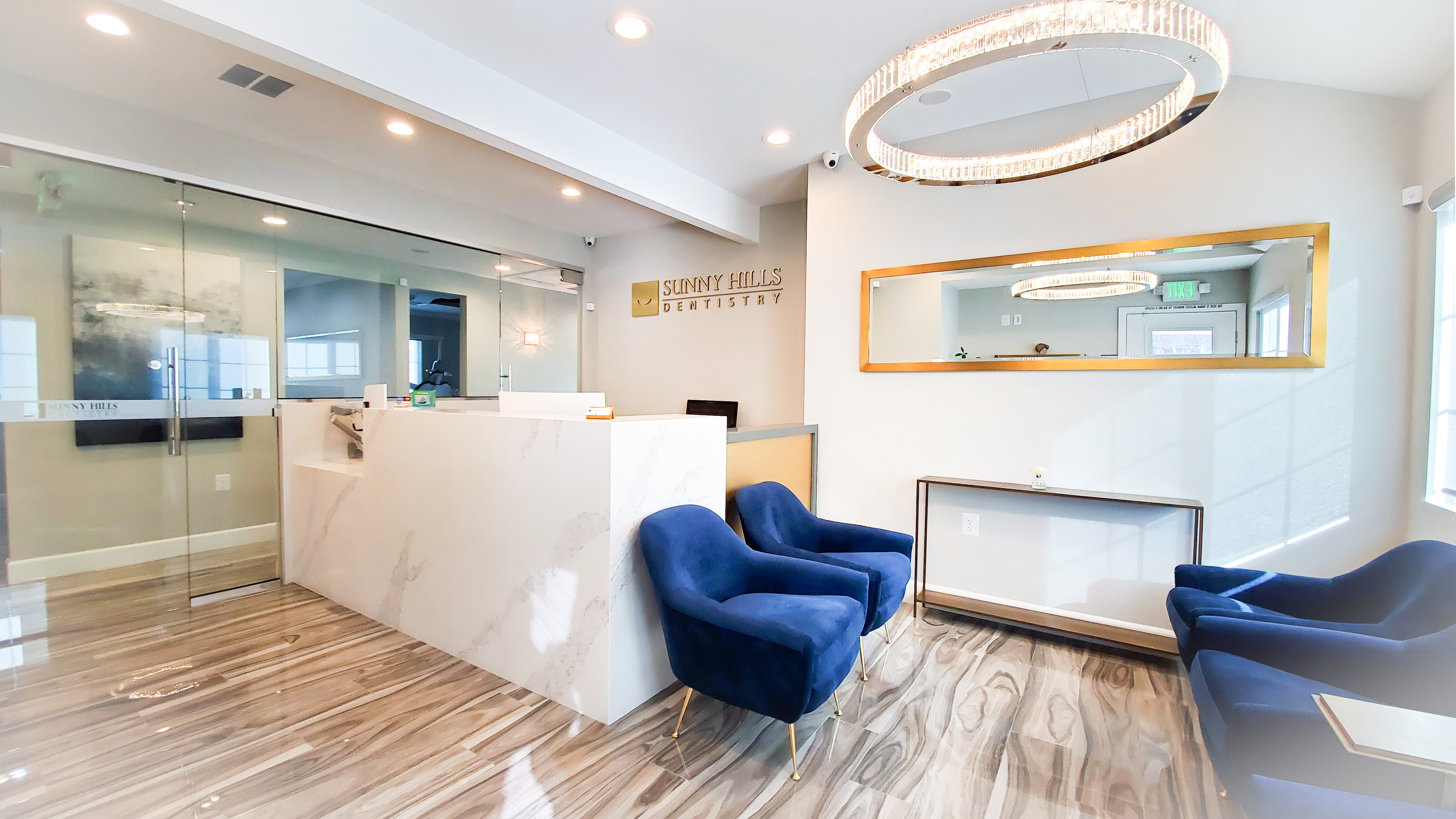 Sunny Hills Dentistry beautiful reception area with blue velvet chairs and marble counter