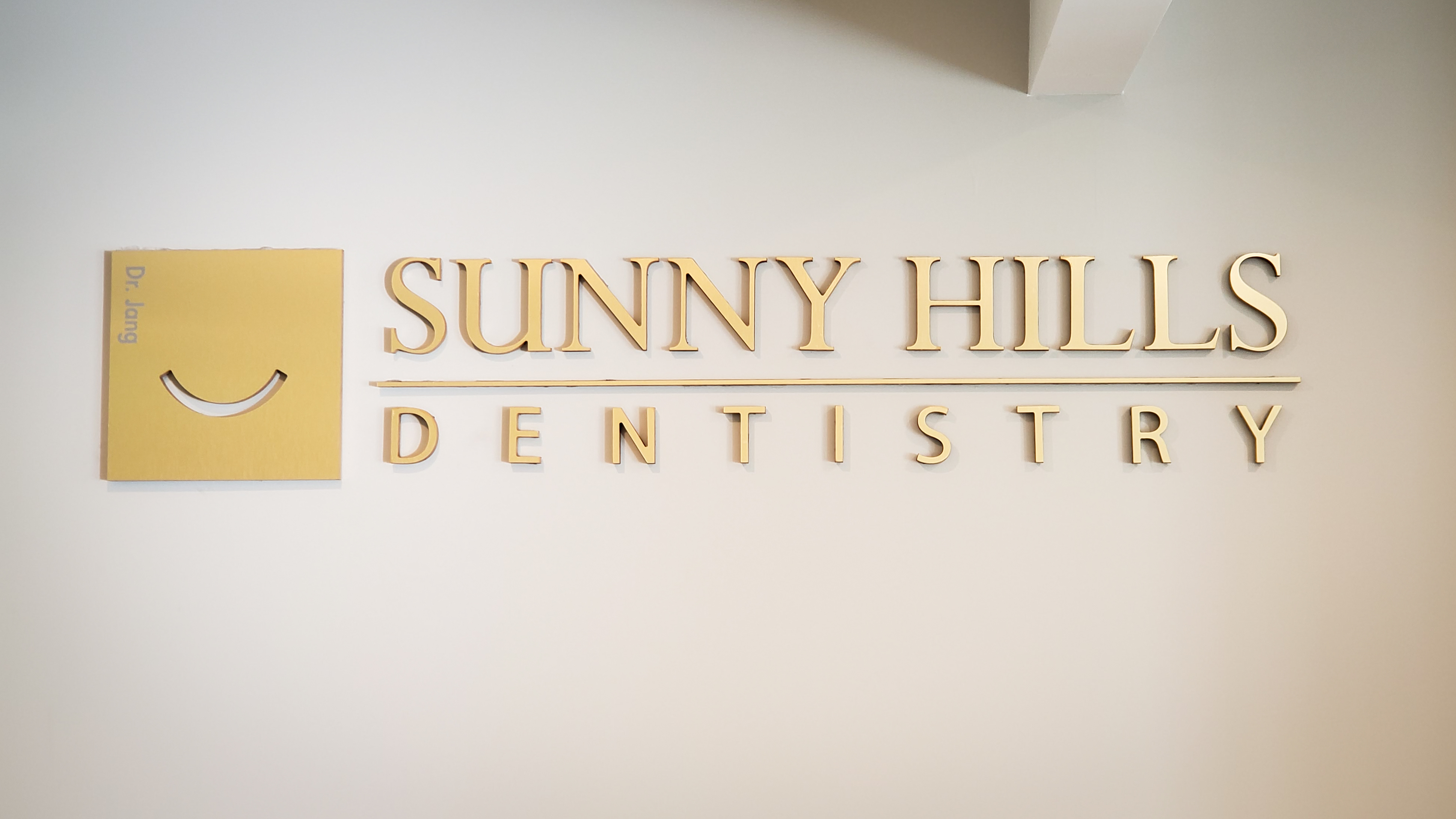 Sunny Hills Dentistry gold wall sign in the office